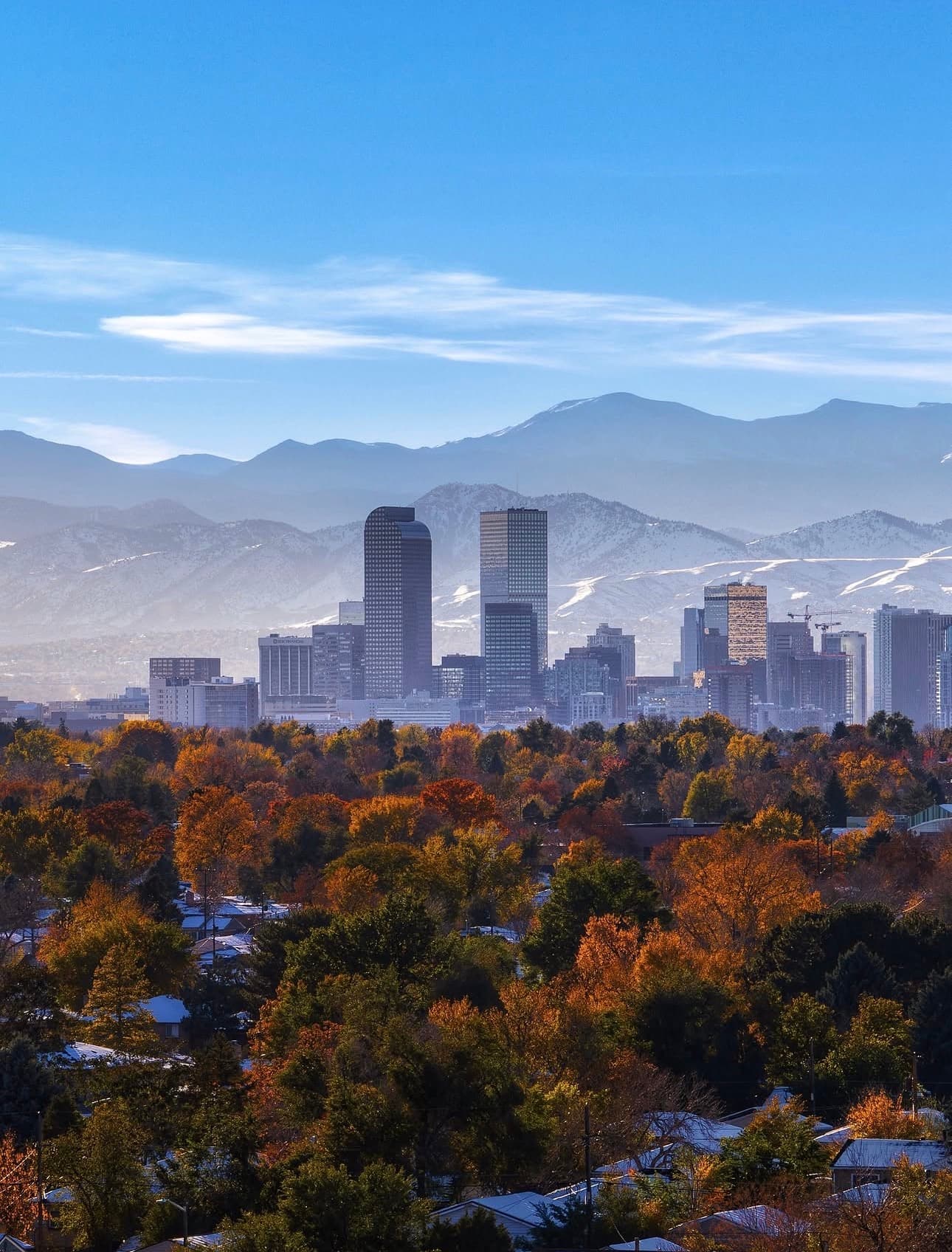 Denver skyline with snow-capped Rocky Mountains and fall foliage