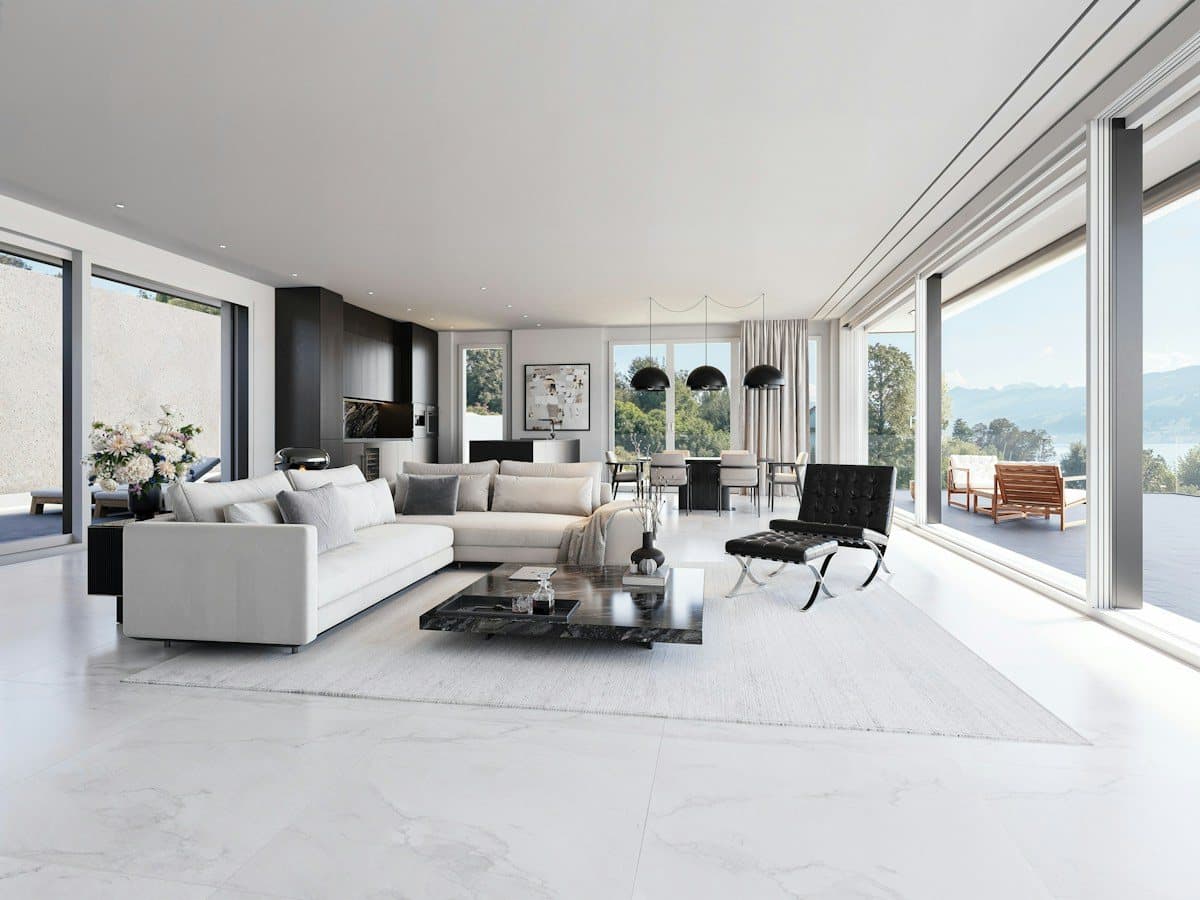 Luxury living room with floor-to-ceiling glass opening to mountain and lake views