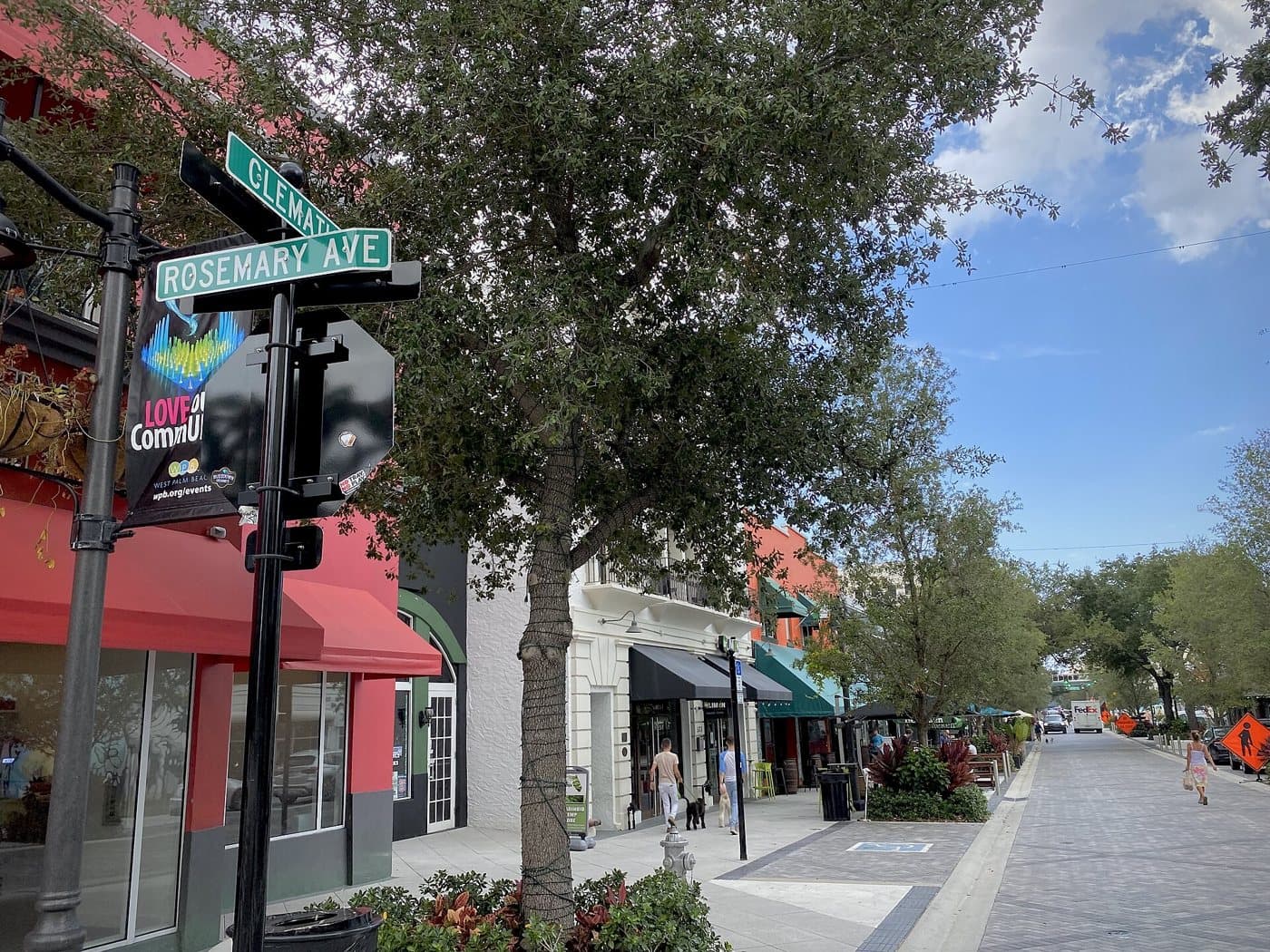 Shaded Clematis Street in downtown West Palm Beach with shops and cafe seating